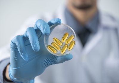 nutritional supplements cod liver oil omega 3 vitamin d,a fish oil capsules, capsule oil in researcher hand