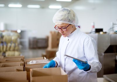 young gorgeous concerned female worker in sterile cloths using a